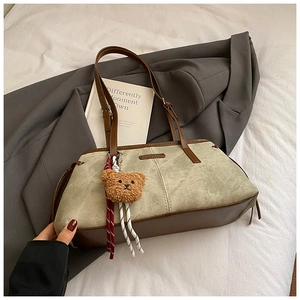 Détail du sac patchwork en daim et cuir avec breloque ours en peluche et étiquette