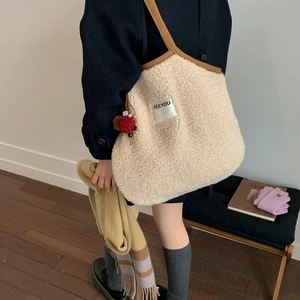 Detail of beige fleece tote bag with brown straps and SEEYOU label on minimalist background