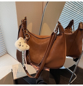 Brown vintage faux leather dumpling bag with metal chain and cute white bear charm detail