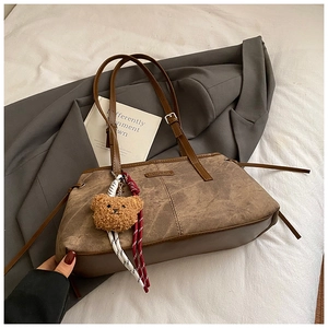 Gros plan du sac sous le bras en cuir marron vintage avec un ours en peluche et corde tressée