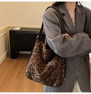Macro detail of high-capacity canvas tote bag featuring classic leopard print and logo