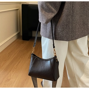 Detail view of vintage leather bag with jacquard strap and minimalist metallic hardware