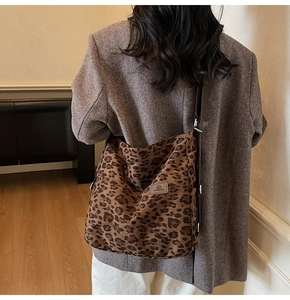 Detailed back view of a person carrying the large leopard print canvas tote bag