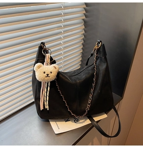 Detail of black lychee grain Hobo bag with metal chain and cute white bear charm