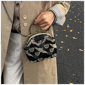 Detail of crane embroidery and antique metal clasp on a vintage Chinese style crossbody bag
