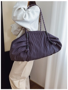 Détail du sac cabas plissé violet foncé avec bretelles en corde et texture de tissu