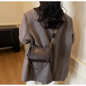 Detail of dark brown vintage hobo bag showing wrinkled leather texture and jacquard strap