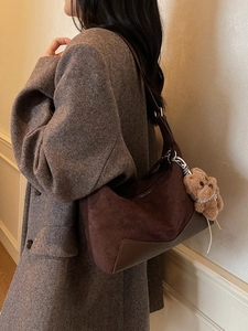 Dunkelbraune Hobo-Tasche aus Wildlederimitat mit Hundeanhänger von Model getragen