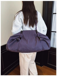 Vue détaillée du sac cabas plissé violet montrant la texture froissée et la bandoulière tressée