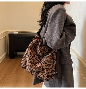 Detail of leopard print canvas tote bag with adjustable black strap on shoulder
