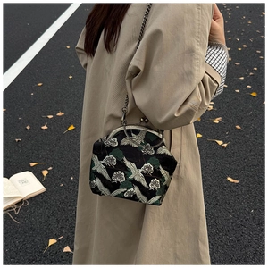 Detail of vintage black crossbody bag with white crane and pine tree embroidery