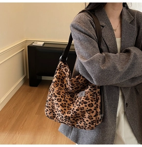 Close-up of leopard print canvas tote bag with woven shoulder strap and brand label
