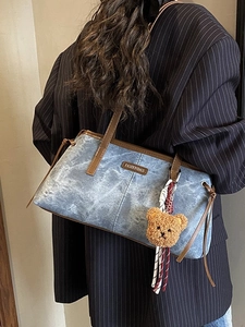 Sac bandoulière rétro en denim bleu avec anses en cuir marron et pendentif ours peluche
