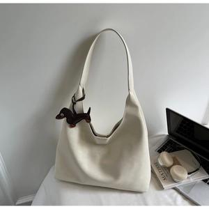 Close-up of cream soft leather hobo tote bag with brown dachshund pendant detail