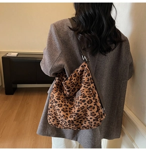 Detail shot of large leopard print tote bag with brown shoulder strap on model