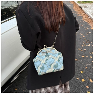 Detail of vintage embroidery crossbody bag featuring crane and wave patterns on blue silk