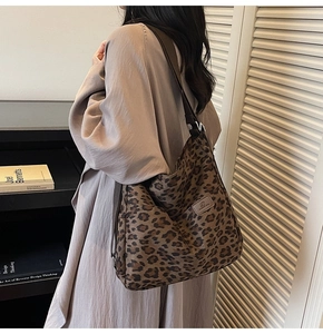 Detail view of leopard print canvas tote bag showing large capacity on model shoulder