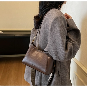 Brown vintage PU leather hobo bag with wide patterned strap shown on a model