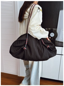 Détail du sac cabas noir à cordon avec bandoulière tressée tricolore et tissu plissé