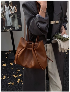 Detailansicht der braunen Leder-Beuteltasche mit dekorativen Knoten und schlanken Trägern