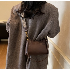 Detail view of dark coffee leather bucket bag with bohemian jacquard shoulder strap