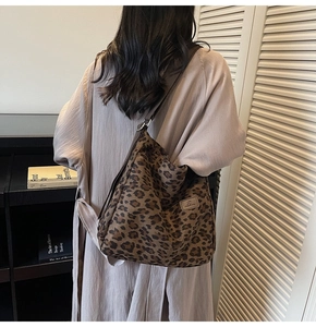 Detail view of large leopard print canvas tote bag with adjustable brown strap