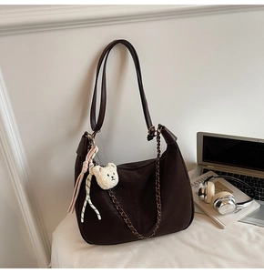 Detail of coffee brown moon bag with brown chain, bear pendant and mesh strap décor