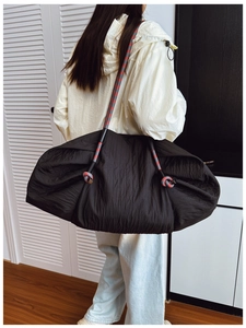 Détail du sac cabas plissé noir avec bandoulière en corde tressée rouge et grise