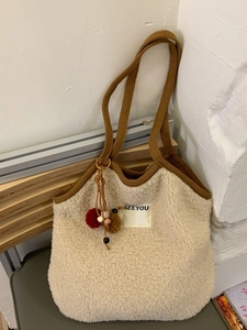 Winter fluffy faux shearling tote bag in creamy white with brown knit handles and pom-poms