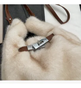 Dettaglio borsa beige in ecopelliccia con manico in pelle e chiusura a girello in metallo