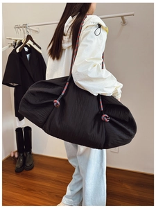 Détail du grand sac cabas noir matelassé avec une bandoulière en corde tressée colorée