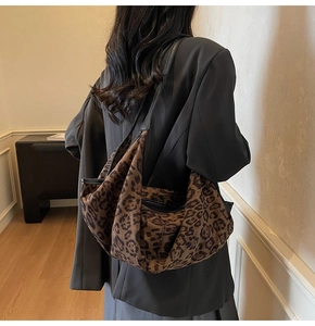 Detail of leopard print hobo bag showing faux suede texture and black trim on the shoulder strap