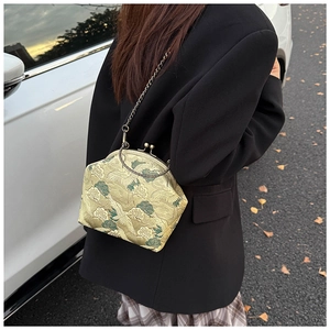 Detail of vintage frame bag featuring elegant crane embroidery and metallic chain strap
