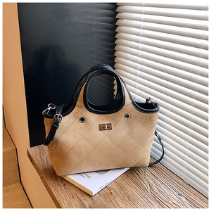 Detailed view of khaki suede tote with diamond stitching and silver twist lock closure