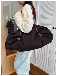 Détail du sac cabas plissé noir avec bandoulières en corde tressée rouge et grise