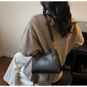 Detail of black trapezoid hobo bag with an ethnic patterned wide woven shoulder strap