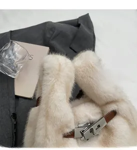 Dettaglio ravvicinato della borsa in ecopelliccia con chiusura a rotazione e pelle