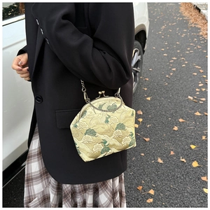 Detailed close-up of crane embroidery on retro crossbody bag with vintage metal handle