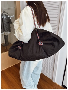 Détail du sac cabas plissé noir avec bandoulières en corde tressée rouge et gris