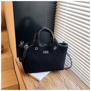 Detailed view of black quilted tote bag with matte finish and silver metal twist lock