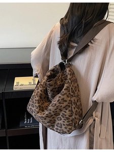 Stylish large leopard print canvas tote bag shown worn over the shoulder by a model