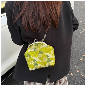 Detail of green silk crossbody bag with crane embroidery and gold metal clasp