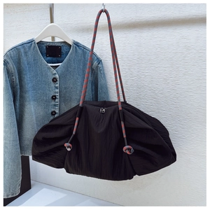 Détail d'un sac cabas plissé noir avec des anses en corde tressée rouge et grise
