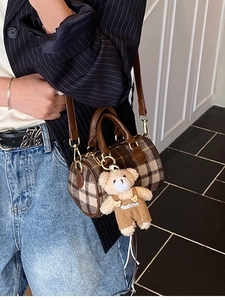 Vintage checkered cylinder handbag with leather straps and a plush bear pendant