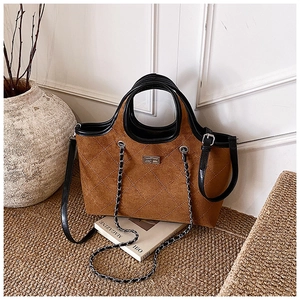 Detailed view of the diamond quilted brown suede tote bag with black leather handle details