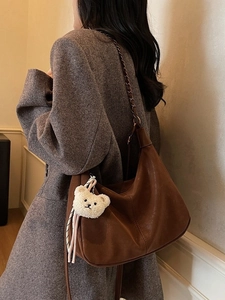Brown leather hobo shoulder bag with metal chain strap and plush bear accessory
