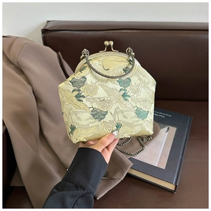 Detail of vintage crane embroidery on champagne brocade fabric with metal frame closure