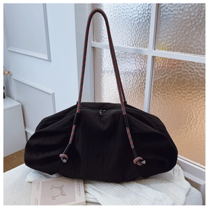 Détail du sac cabas plissé noir avec bandoulière en corde tressée et surface texturée