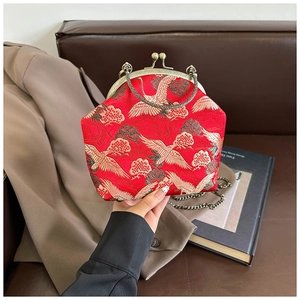 Detail of red Chinese crane embroidery on a vintage satin crossbody bag with bronze clasp