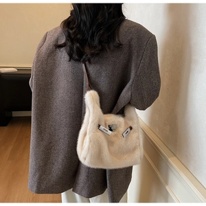 Dettaglio della borsa a tracolla in pelliccia sintetica con cinturini in pelle su modella